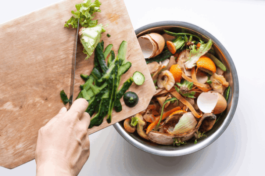 Une personne jette des détritus de légumes